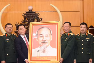 Đồng chí Nguyễn Trọng Nghĩa trao ảnh Bác Hồ tặng Ban Giám đốc Học viện Chính trị (Bộ Quốc phòng).
