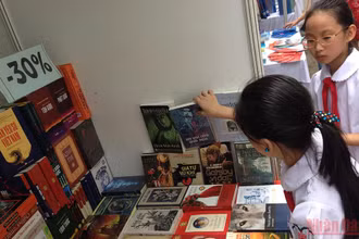 Xây dựng văn hóa đọc sâu rễ bền gốc từ lứa tuổi nhỏ là nhiệm vụ quan trọng. (Ảnh: Các em học sinh tham khảo sách tại khu trưng bày nhân Ngày Sách Việt Nam của Thư viện Quốc gia)