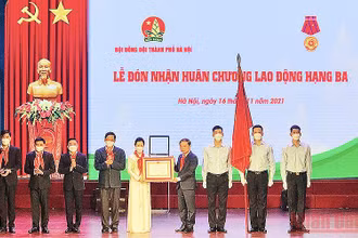 Đồng chí Phạm Tất Thắng (thứ tư từ bên phải sang trong ảnh) thừa ủy quyền của Chủ tịch nước, trao Huân chương Lao động hạng ba tặng Hội đồng Đội thành phố Hà Nội. 