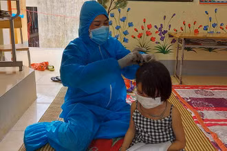 Giáo viên Trường Phổ thông dân tộc bán trú Tiểu học Thuận Hòa giúp đỡ học sinh trong khu cách ly. Ảnh: Nguyễn Thảo