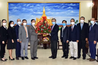 Đại sứ Nguyễn Bá Hùng (trái) chúc mừng và đánh giá cao những thành tựu phát triển kinh tế-xã hội mà Lào đạt được trong 46 năm qua. (Ảnh: Đại sứ quán Việt Nam tại Lào)