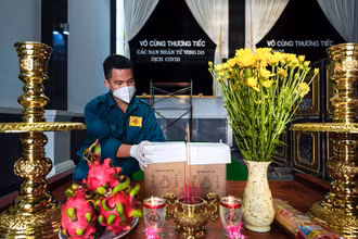 Một chiến sĩ dân quân tự vệ thắp hương cho một nạn nhân tử vong trong dịch Covid-19. Ảnh: Hoàng Triều.