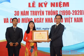 PGS, TS Đặng Thị Thu Hương và TS Nguyễn Sơn Minh đại diện lãnh đạo Viện đón nhận Bằng khen từ Thứ trưởng Giáo dục và Đào tạo Hoàng Minh Sơn. Ảnh: AN PHONG.