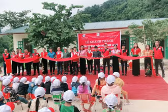 Đại diện đơn vị tài trợ và Ban Giám hiệu Trường PTDT Bán trú Tiểu học số 2 Nà Hỳ cắt băng khánh thành đưa vào sử dụng phòng học mới.