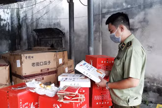 Cán bộ quản lý thị trường kiểm tra chất lượng sản phẩm bánh, kẹo nhập khẩu. (Ảnh: NGUYÊN TRANG)