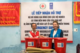 Bà Caitlin Wiesen trao đồ hỗ trợ cho người dân vùng bị ảnh hưởng bão lụt.