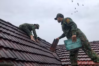 Bộ đội biên phòng Quảng Bình giúp người dân huyện Bố Trạch lợp lại nhà.