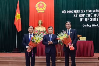 Ông Trần Hải Châu (trái) và ông Trần Thắng (phải) nhận hoa chúc mừng của Bí thư Tỉnh ủy Quảng Bình Vũ Đại Thắng.