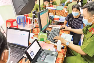 Cán bộ công an hỗ trợ người dân làm thẻ căn cước công dân có gắn chíp tại Nhà văn hóa liên phường Bình Trị Đông, quận Bình Tân. (Ảnh: QUÝ HIỀN)