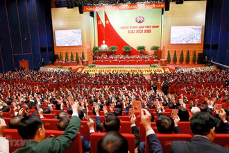 Các đại biểu biểu quyết, thông qua Nghị quyết Đại hội XIII Đảng Cộng sản Việt Nam. (Ảnh: TTXVN)