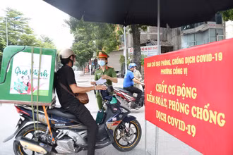 Lực lượng chức năng phường Cống Vị, quận Ba Đình kiểm tra giấy tờ tùy thân tại chốt kiểm soát dịch Covid-19 trên phố Đội Cấn. (Ảnh: THANH HẢI)