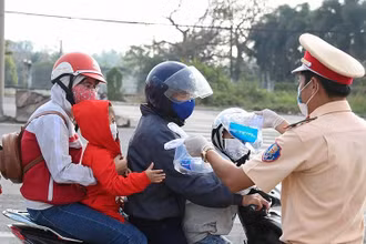 Lực lược CSGT phát khẩu trang, nước uống, khăn lạnh cho người dân trên quốc lộ 51.