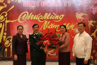 Chủ tịch Quốc hội Lào Pany Yathotou (thứ hai từ phải sang) tặng hoa chúc mừng năm mới cán bộ, chiến sĩ Binh đoàn 11, chiều 11-2.