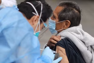 Một người đàn ông vô gia cư được tiêm vaccine Covid-19 ở Los Angeles, California, Mỹ, ngày 10-2 . Ảnh: Reuters.
