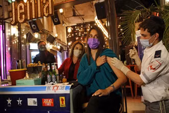 Tiêm vaccine bên trong một quầy bar ở Tel Aviv. (Ảnh: Getty Images)