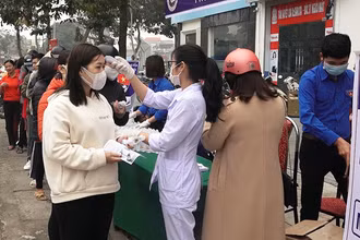Nhân viên y tế kiểm tra thân nhiệt, cấp phát vật tư phòng dịch cho nhân dân ở huyện Hoằng Hóa.