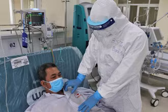 BS Toàn kiểm tra tình hình sức khỏe cho bệnh nhân COVID-19 trong phòng ICU (chăm sóc tích cực).