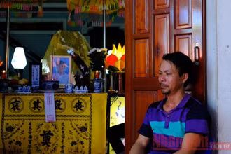 Ông Đặng Minh Vương thẫn thờ bên di ảnh của con là cháu Đặng Minh Nhật.