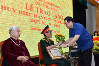 Ủy viên Bộ Chính trị, Bí thư Thành ủy Vương Đình Huệ trao Huy hiệu 75 năm tuổi Đảng các đồng chí đảng viên. (Ảnh: DUY LINH)