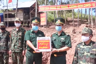 Đại tá Lê Văn Phương (bên phải) tặng quà cho chiến sĩ làm nhiệm vụ tại chốt phòng, chống Covid-19 thuộc Đồn Biên phòng cửa khẩu quốc tế La Lay.