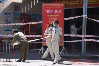 Lực lượng chức năng đặt barie chốt phong toả phía trước cổng chợ Tân Lập sáng 22-8.