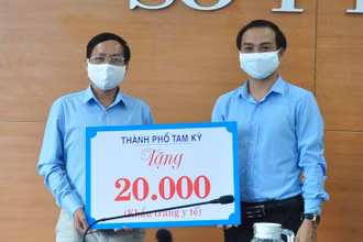 Phó Chủ tịch UBND TP Tam Kỳ Nguyễn Hồng Lai (bên phải) trao biểu trưng 20 nghìn khẩu trang cho Sở Y tế. 