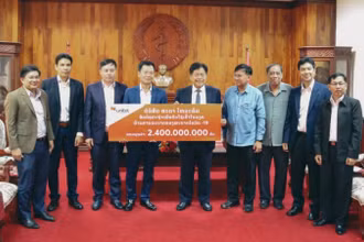 Bộ trưởng Y tế Lào Bounkong Sihavong (giữa) nhận tượng trưng 2,4 tỷ kíp Lào của Tổng Giám đốc Công ty Star Telecom Lưu Mạnh Hà.