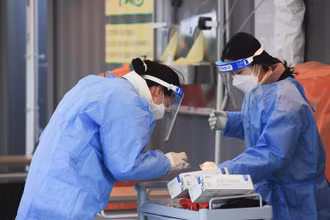 Nhân viên y tế lấy mẫu xét nghiệm Covid-19 tại Seoul, Hàn Quốc. (Ảnh: AP)