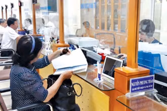 Cán bộ UBND quận Hoàn Kiếm tiếp nhận, hướng dẫn người dân làm thủ tục hành chính tại bộ phận “Một cửa”.