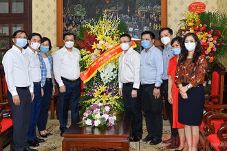 Đồng chí Đinh Tiến Dũng, Ủy viên Bộ Chính trị, Bí thư Thành ủy Hà Nội cùng các đồng chí lãnh đạo thành phố tặng hoa chúc mừng Báo Nhân Dân. Ảnh: Duy Linh
