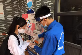 Các thí sinh được kiểm tra thân nhiệt và sát khuẩn tay trước khi vào phòng thi.