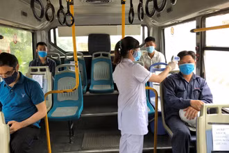 Nhân viên y tế đo thân nhiệt trên xe buýt đưa, đón công nhân miễn phí.