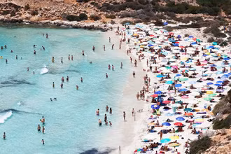 Du khách trên bãi biển trên đảo Lampedusa của Sicilia ngày 22/6/2021 (Ảnh: REUTERS)