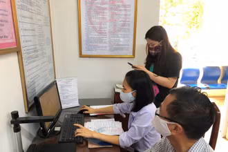 Cán bộ bộ phận một cửa phường Ngọc Lâm (quận Long Biên, Hà Nội) hướng dẫn công dân và nhập trên máy tính thực hiện dịch vụ công mức độ 3.