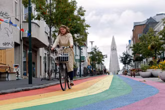 Người phụ nữ đạp xe trên “đường cầu vồng” tại thủ đô Reykjavik của Iceland. (Ảnh: Reuters)
