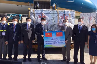 GS, TS Nguyễn Thanh Long - Bộ trưởng Y tế Việt Nam và ngài Hùng Ba - Đại sứ đặc mệnh toàn quyền nước CHND Trung Hoa trao biên bản bàn giao lô hàng viện trợ gồm 500.000 liều vaccine và hơn 500.000 bơm kim tiêm. (Ảnh: TRẦN MINH)