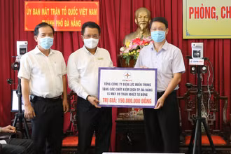 Tổng Giám đốc EVNCPC Ngô Tấn Cư (bên trái) trao bảng tượng trưng kinh phí hỗ trợ mua vaccine và 15 máy đo thân nhiệt tự động.