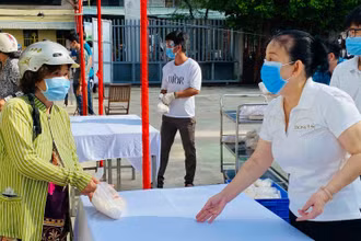 Bà Le Thị Kim Thu, đại diện Đại lý vé số Trương Thị Ngọc Thủy tặng quà cho người dân.