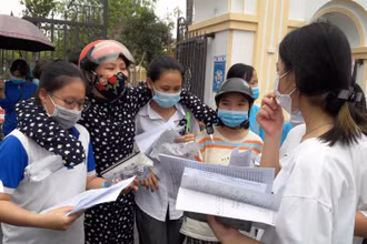 Giáo viên động viên thí sinh tại địa điểm thi THPT Quảng Xương 1, tỉnh Thanh Hóa.