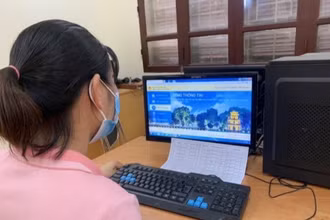 Túc trực hỗ trợ cha mẹ học sinh đăng ký thử nghiệm tuyển sinh trực tuyến tại Trường tiểu học Ba Trại B, huyện Ba Vì. 