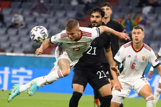 Trung vệ Hungary Andras Schafer (áo trắng phía trước) cản phá bóng trong trận đấu với đội tuyển Đức ở lượt cuối bảng F trên sân Allianz tại Munich. 