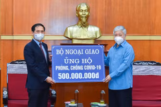 Bộ trưởng Ngoại giao Bùi Thanh Sơn trao tượng trưng số tiền 500 triệu đồng tới Bí thư Trung ương Đảng, Chủ tịch Ủy ban Trung ương Mặt trận Tổ quốc Việt Nam Đỗ Văn Chiến. (Ảnh: MOFA)