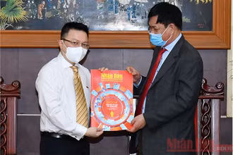Đồng chí Lê Quốc Minh tặng đồng chí Huỳnh Tấn Việt (bên phải) số báo đặc biệt nhân ngày 21-6. (ẢNH: THỦY NGUYÊN)