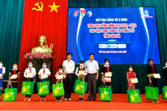 Ông Nguyễn Trân Châu, Phó Giám đốc Thường trực Quỹ “Học bổng Vừ A Dính”, Phó Tổng Biên tập Báo Thiếu niên Tiền phong và Nhi đồng trao học bỗng cho các em học sinh.