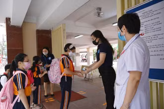 Học sinh Trường tiểu học Thăng Long (Hoàn Kiếm, Hà Nội) rửa tay sát khuẩn, kiểm tra thân nhiệt trước khi vào trường học trực tiếp. (Ảnh: Duy Linh)