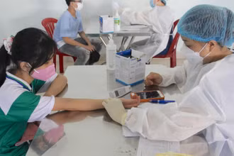 Các em được khám sàng lọc trước khi tiêm vaccine.