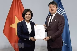 Đại sứ Lê Thị Tuyết Mai trao văn kiện Việt Nam gia nhập Hiệp ước WIPO về buổi biểu diễn và bản ghi âm cho Tổng giám đốc WIPO Daren Tang. (Ảnh: TTXVN)