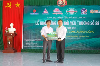 Lãnh đạo Công ty Nhựa Tiền phong trao bảng tượng trưng. (Ảnh: BÁ DŨNG) 