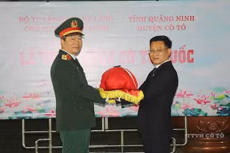 Thiếu tướng Bùi Hải Sơn, Tư lệnh, Bộ Tư lệnh Bảo vệ Lăng Chủ tịch Hồ Chí Minh trao tặng cờ Tổ quốc cho Đảng bộ, chính quyền và nhân dân huyện đảo Cô Tô (Quảng Ninh). (Ảnh: Hoàng Phương)