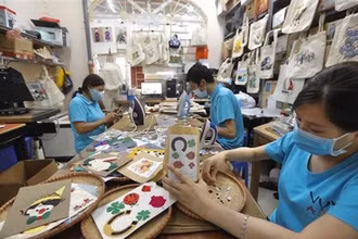 Người khuyết tật sáng tạo các tác phẩm thủ công tại Hợp tác xã Vụn Art ở Hà Đông (Hà Nội). (Ảnh: Minh Quyết/TTXVN)